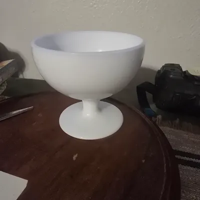 Sale Photo Thumbnail #188: A vintage white milk glass pedestal bowl featuring a smooth, minimalist design. Ideal as a compote dish, planter, or decorative centerpiece. Appears to be in good vintage condition with no visible chips or cracks.