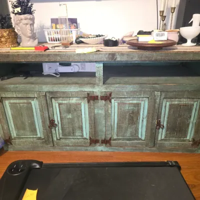 Sale Photo Thumbnail #202: 29x60x22 rustic wooden sideboard or media console featuring a distressed teal and natural wood finish. Designed with four paneled cabinet doors accented by dark metal hinges and loop pulls, plus two open upper shelving compartments. Shows some wear consis
