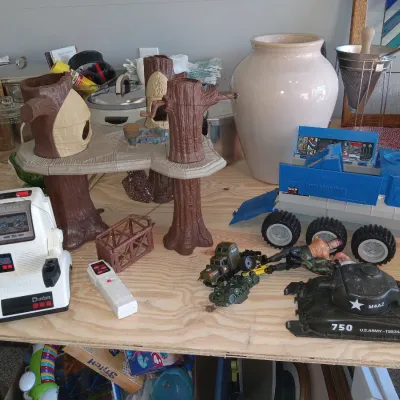 Assortment of vintage 1980s toys, including a Chatbot robot with remote, an Ewok Village playset, and various military vehicles and...