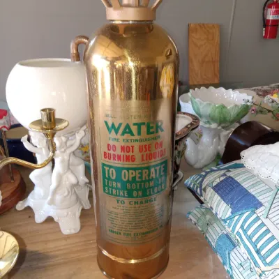 Vintage Badger Fire Extinguisher Company brass water fire extinguisher, featuring original painted instructions and a gold-tone handle.