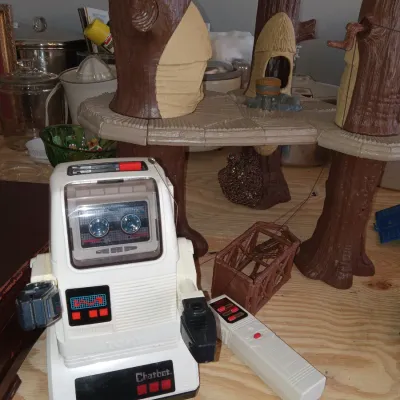 Vintage 1980s Tomy Chatbot toy robot with its wired remote control, shown alongside a Kenner Star Wars Ewok Village playset.