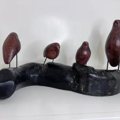 Decorative Wood Carving Featuring Four Small Birds Perched On A Curved Branch