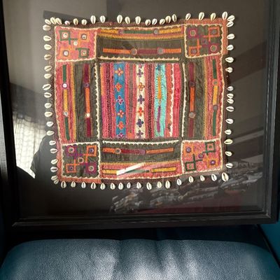 embroidered and beaded African textile framed in a shadow box