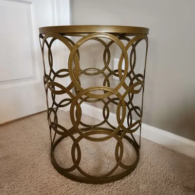 Gold-finished openwork iron accent table.