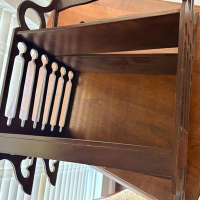 Sale Photo Thumbnail #99: Vintage dark-stained wooden magazine rack or book trough featuring decorative cutout side panels.