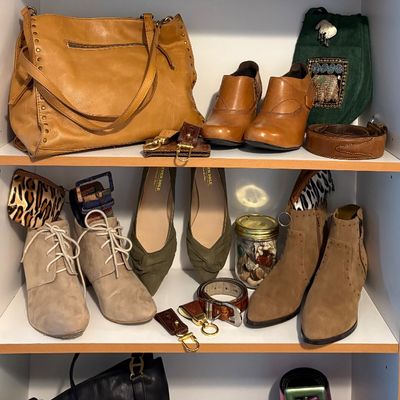 Sale Photo Thumbnail #89: Assortment of women's shoes, handbags, and belts displayed on white shelving, including leather ankle boots, flats, and rain boots.