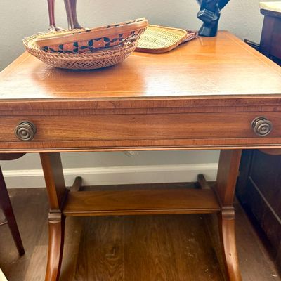 Sale Photo Thumbnail #97: Duncan Phyfe style mahogany drop-leaf table featuring a single drawer with brass pulls, splayed legs on casters, and a central stretcher.