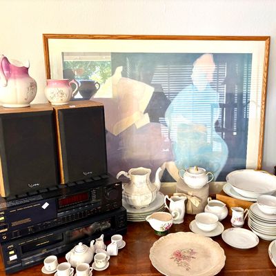 Sale Photo Thumbnail #85: Assorted vintage tableware including floral porcelain plates, teacups, and pitchers, displayed alongside a JVC stereo system, Infinity speakers, and a large framed print.