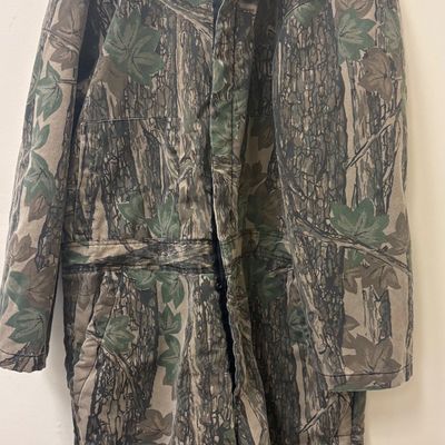 Insulated camouflage hunting coveralls featuring a realistic forest and leaf pattern, complete with a quilted lining and front zipper...