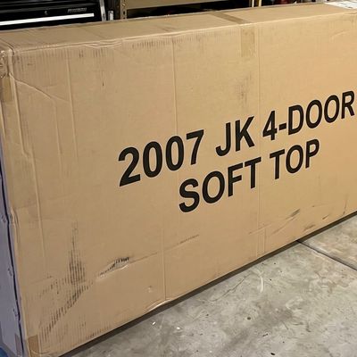 Large cardboard shipping box containing a soft top for a 2007 Jeep Wrangler JK 4-door.