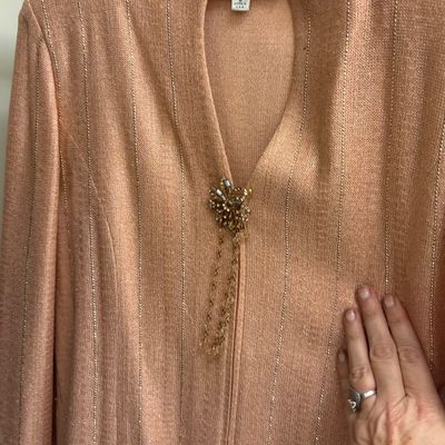 St. John Evening knit jacket in a peach hue with metallic gold vertical pinstripes, featuring a jeweled clasp closure with hanging chains.