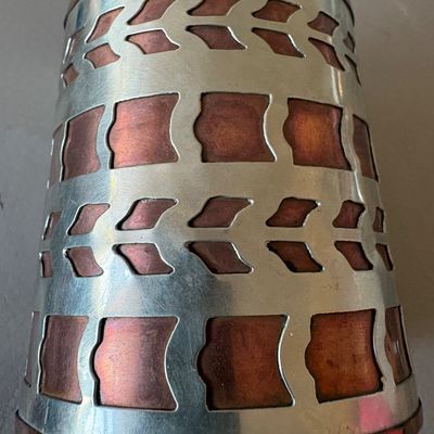 Vintage mixed-metal cuff bracelet featuring a cut-out silver-tone overlay on a copper base with geometric patterns.