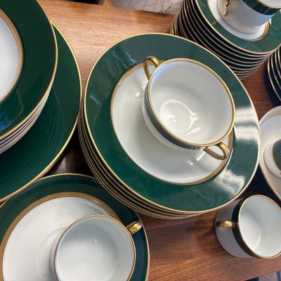 Vintage porcelain dinnerware set featuring a deep forest green band and elegant gold trim, including plates, double-handled soup bowls,...