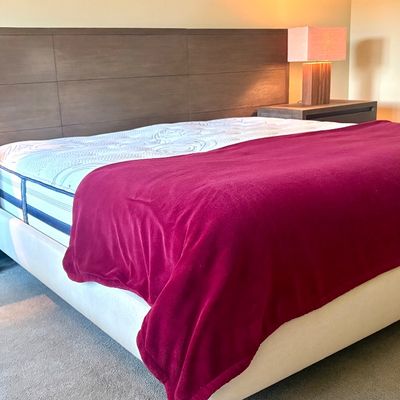 Contemporary king-size platform bed featuring an integrated extra-wide wood panel headboard and matching three-drawer nightstands with...