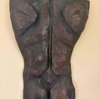 Abstract wall sculpture depicting a stylized male torso back, finished in a dark, textured bronze-like patina.