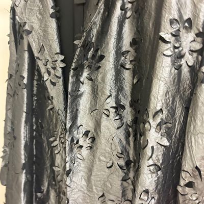 Doncaster Collection metallic silver coat featuring a textured fabric with laser-cut floral details.