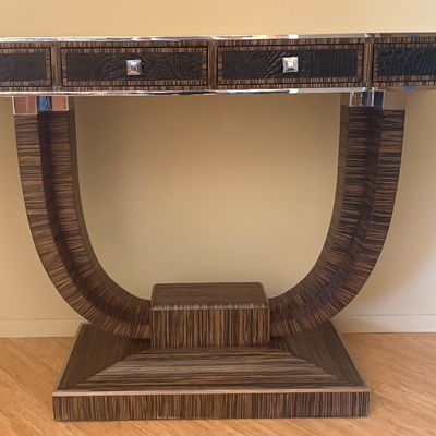 Art Deco style console table featuring a zebrawood veneer, a U-shaped pedestal base, and four drawers with faux-alligator skin fronts and...