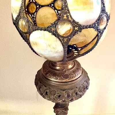 Antique slag glass and metal floor lamp featuring a spherical shade with ornate metalwork and a marble pedestal base.