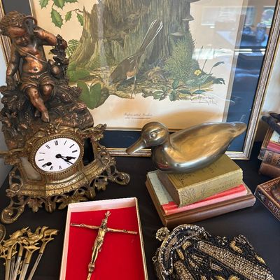 Assortment of vintage collectibles, including an ornate brass cherub clock, a brass duck figurine, a framed Ray Harm bird print, a beaded...