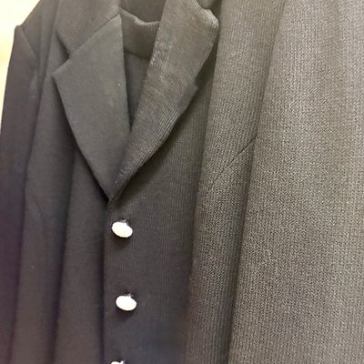 St. John Basics black knit blazer with white and silver-tone buttons, size M, shown hanging on a wire hanger.