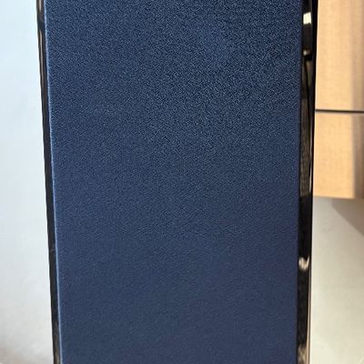Revel floorstanding speaker featuring a black fabric grille and a glossy black cabinet.