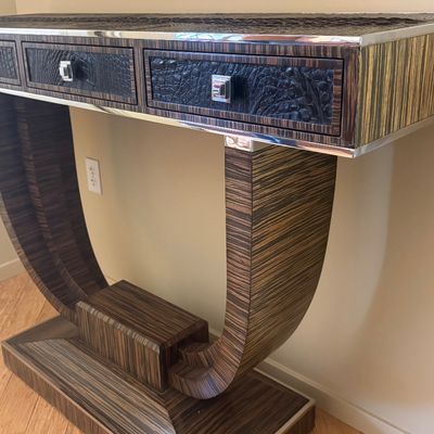 Art Deco style console table featuring zebrano wood veneer, curved pedestal supports, and drawers with faux-crocodile leather fronts and...