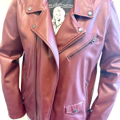 Burgundy faux leather moto jacket featuring asymmetrical zipper closure, zippered pockets, and snap-down lapels.