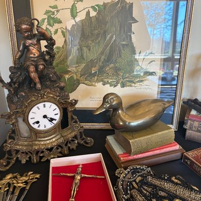 Assortment of vintage collectibles including an ornate bronze cherub mantel clock, a brass duck figurine, a framed Ray Harm bird print, a...