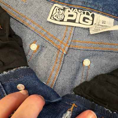 Nasty Pig brand blue denim jeans, size 32, featuring orange contrast stitching and a button fly.