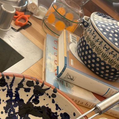 Assorted kitchenware including a blue and white splatter-patterned bowl, Polish pottery covered dish, vintage orange-patterned glass...