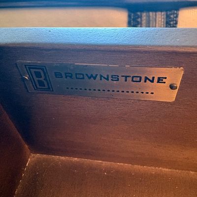 Brownstone Furniture maker's mark metal plate, mounted inside a wooden drawer.