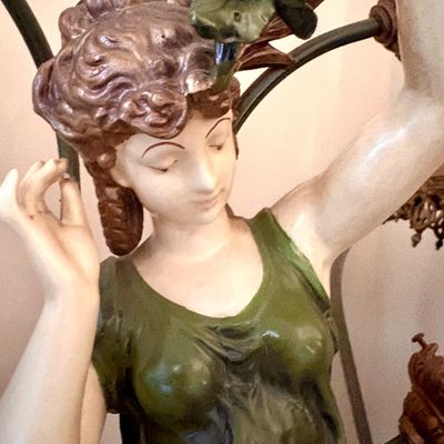 Art Nouveau style painted plaster or composite female figure, depicted holding grapes, likely part of a decorative lamp base.