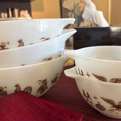 Vintage Pyrex Early American pattern Cinderella mixing bowls, featuring brown Americana motifs on white milk glass.
