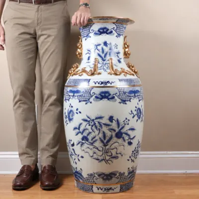 Large Chinese-style blue and white porcelain floor vase featuring intricate floral motifs and gilded dragon handles.