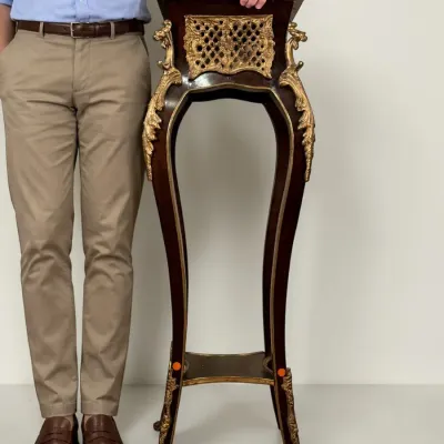 French Louis XV-style mahogany pedestal stand featuring ornate gilt bronze ormolu mounts, a pierced decorative apron, and a lower tier...