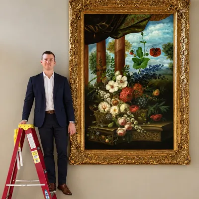 Large-scale Dutch Golden Age style floral still life oil painting, housed in an ornate, heavily carved giltwood frame.
