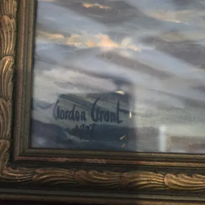 Sale Photo Thumbnail #13: Detail of a framed maritime painting showing the signature of artist Gordon Grant, dated 1927.