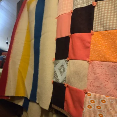 Sale Photo Thumbnail #53: Vintage Hudson's Bay style multi-stripe wool blanket alongside a handmade patchwork quilt with tied yarn details.