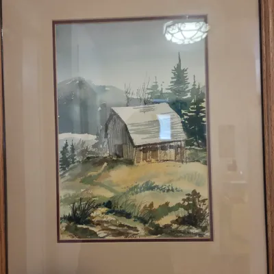 Sale Photo Thumbnail #59: Framed watercolor painting depicting a rustic barn in a mountainous landscape, double-matted in a simple oak frame.