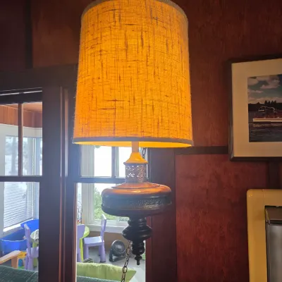 Sale Photo Thumbnail #85: Mid-century modern swag lamp featuring a textured orange burlap shade and a dark wood and metal base, suspended by a brass chain.