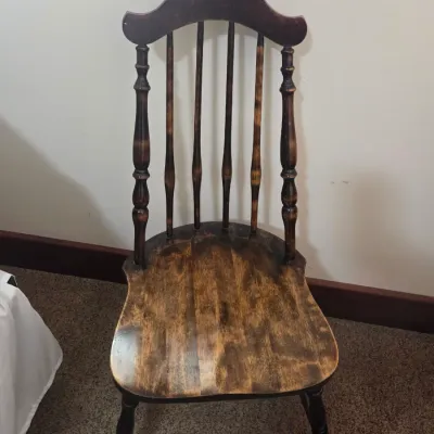 Sale Photo Thumbnail #65: Vintage wooden Windsor-style side chair with a high spindle back, shaped crest rail, and a distressed, dark-stained finish.