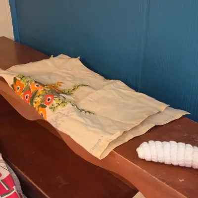 Sale Photo Thumbnail #32: Vintage embroidered linen runner featuring bright orange and yellow floral details, displayed on a wooden shelf.