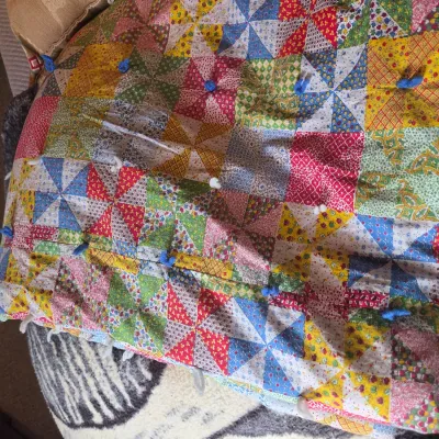 Sale Photo Thumbnail #74: Vintage handmade pinwheel pattern quilt featuring colorful patterned fabric squares and blue yarn tufts.