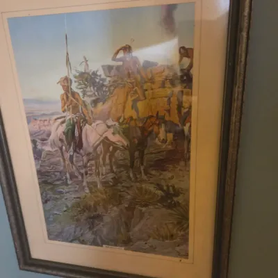 Sale Photo Thumbnail #46: Framed vintage print depicting Native American scouts on horseback in a desert landscape, housed in a dark wood frame with a light mat.