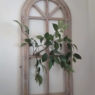 Sale Photo Thumbnail #56: Rustic arched wooden window frame wall decor with a whitewashed finish, adorned with faux green foliage.