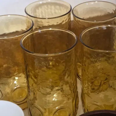 Sale Photo Thumbnail #27: Set of vintage amber glass tumblers featuring a textured, hammered finish and thumbprint details near the base.