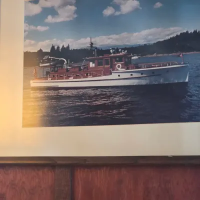 Sale Photo Thumbnail #84: Framed color photograph of a vintage wooden motor yacht on the water, matted and displayed in a wooden frame.