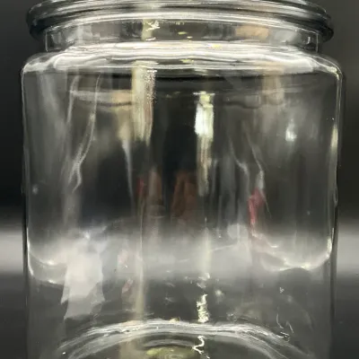 Sale Photo Thumbnail #79: Large clear glass storage jar with a matching glass lid, suitable for kitchen or pantry organization.