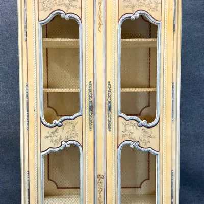 Sale Photo Thumbnail #44: Vintage French Provincial style hand-painted armoire featuring wire-mesh door panels, floral motifs, and a distressed cream finish.