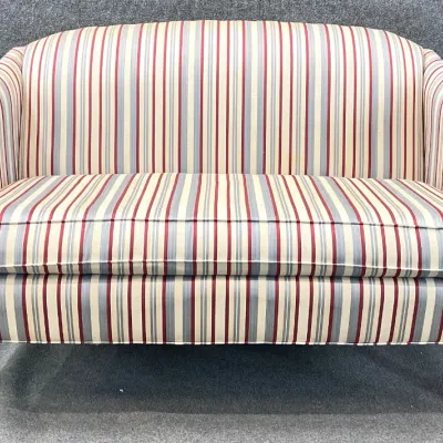 Sale Photo Thumbnail #93: Traditional style settee featuring vertical striped upholstery in cream, red, and blue, supported by a carved wooden frame with turned legs.